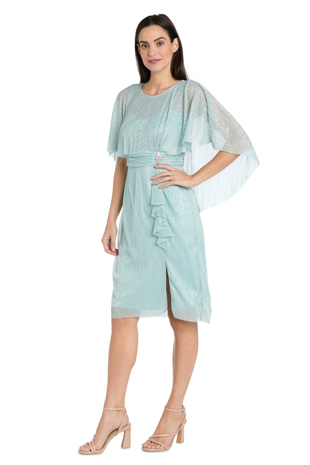Woman wears the Caped Knee-Length Party Dress: R&M Richards 3195P in light blue, featuring ruffled details and flutter sleeves, styled with nude heeled sandals against a white background.